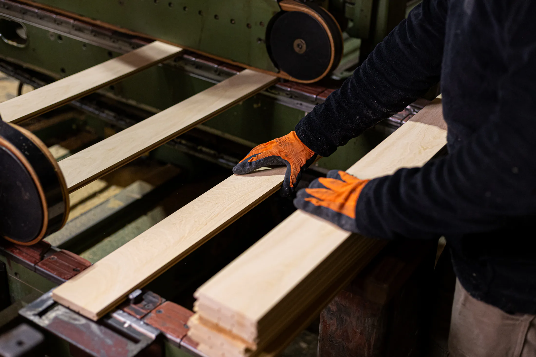 Operario controlando tablas de madera durante el proceso de producción